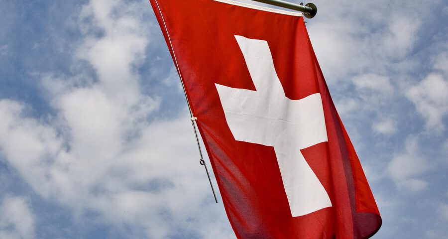 Schweizer Flagge weht vor blauem Himmel